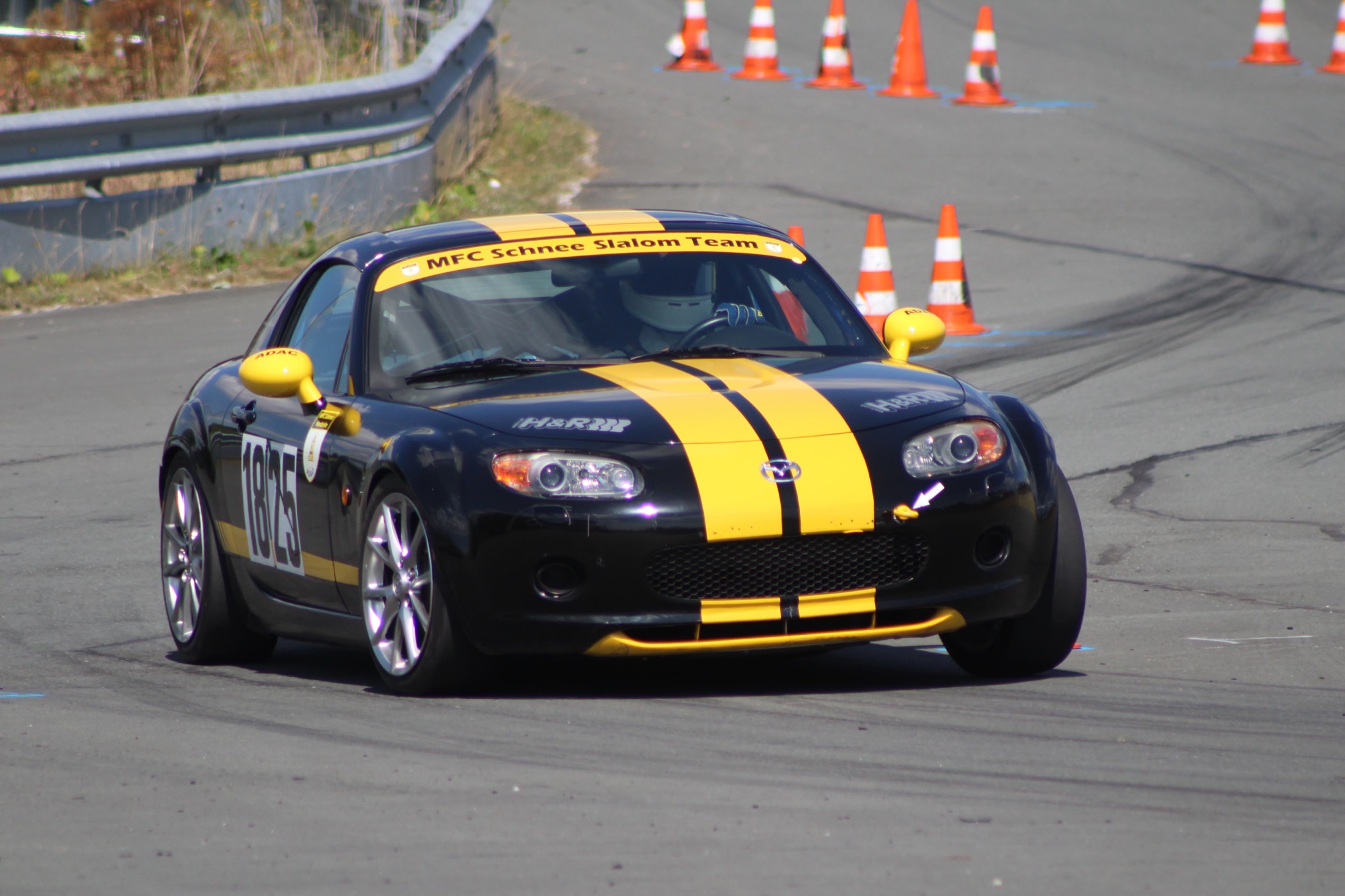 Schwarz-gelber Mazda MX-5 des MFC Schnee Slalom Teams im Pylonen-Parcours